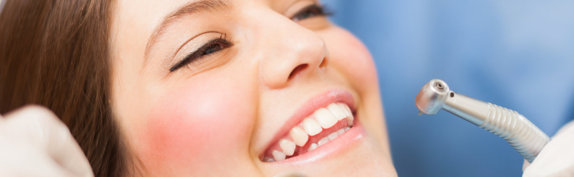 A beautiful woman is smiling after general & preventative dentistry